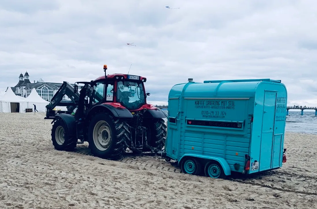 FirstLoveCoffee Kaffeeanhänger wird mit dem Traktor am Strand transportiert