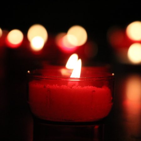 Rote Kerze vor schwarzem Hintergrund